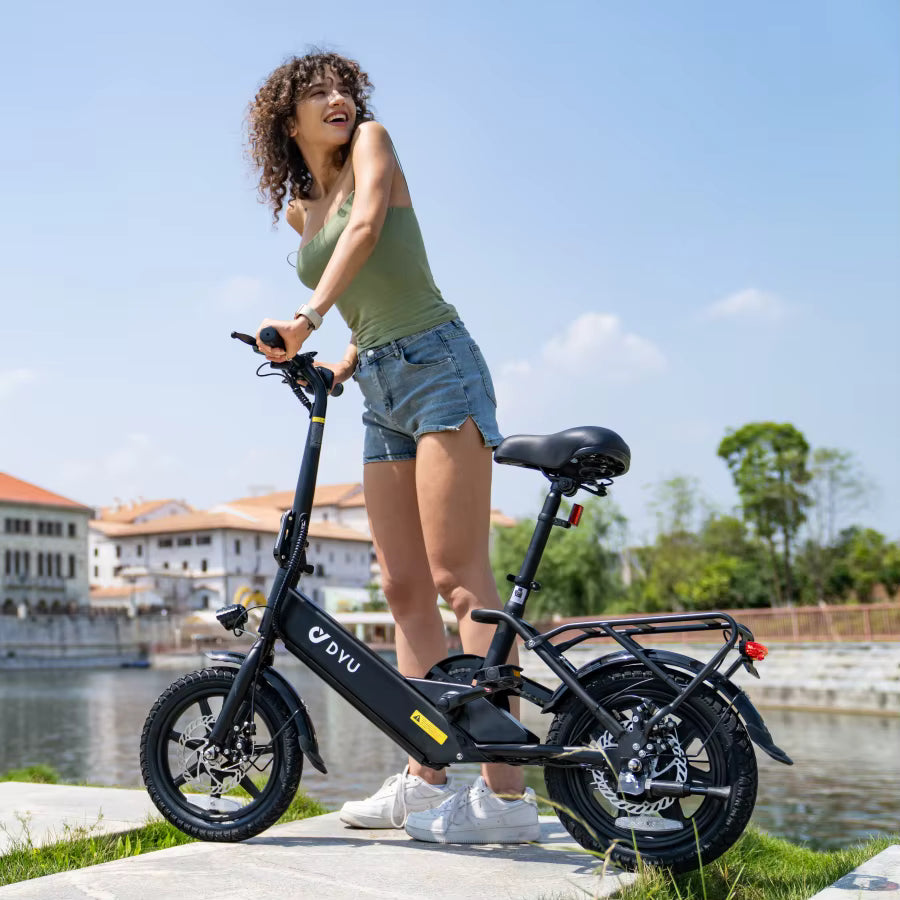 Woman standing next to a black electric bike with a scenic background